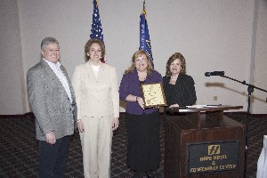 Linda Skinner, chapter director for membership, presents Deb Stanley, Dan Archibald and Billie Common, LDSS Corporation, with a commemorative plaque honoring the company's new corporate membership at the April meeting.